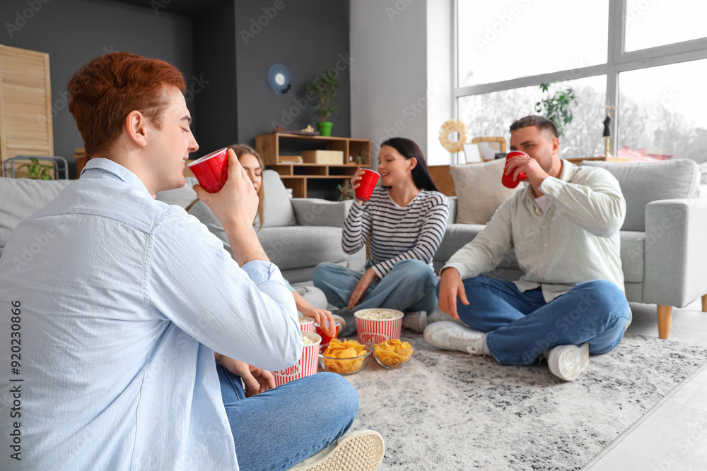 Poster Group of young friends drinking beer at home