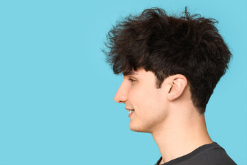 Fototapeta premium Young dark haired man on blue background