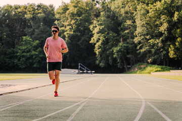 Young man in red sneakers warming up on the athletics track before training