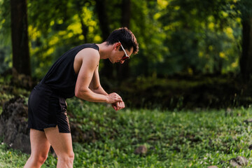 Athlete preparing her smartwatch to start outdoor training session. Copy space