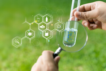 Person with check the water sample in a test tube.