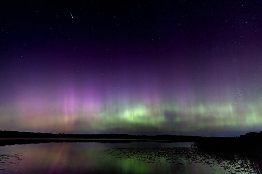 Stunning Aurora Borealis during the Perseids Meteor Shower over a remote lake in Northern Minnesota - A Display of Colors, Shooting Stars and Reflections Under a Starry Dark Sky