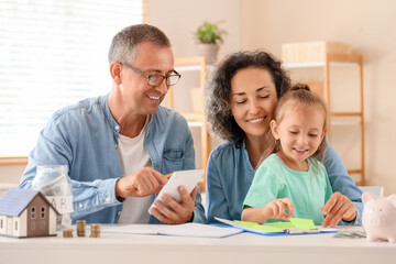Fototapeta premium Happy family with piggy bank and calculator at home