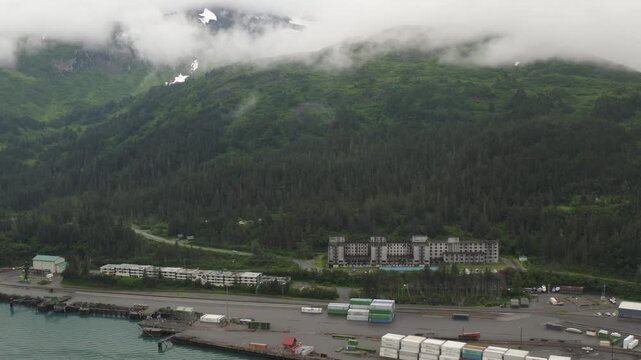 Aerial view of the old U.S. military historic landmark Buckner Building and surrounding mountain area landscape in Whittier, Alaska - 4K Drone