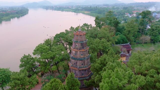 This drone footage captures the serene beauty of the Thien Mu Pagoda in Hue, Vietnam, with a breathtaking aerial view overlooking the tranquil Perfume River. 