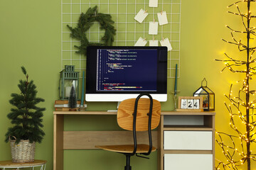 Interior of programmer's office with workplace, Christmas tree and glowing lamp