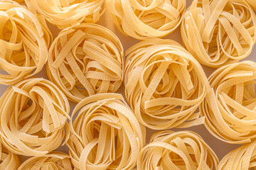 Delicate Italian Fettucine pasta nests background showcasing their texture and shape.