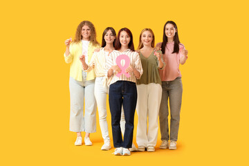 Obraz premium Beautiful women with pink ribbons on yellow background. Breast cancer awareness concept
