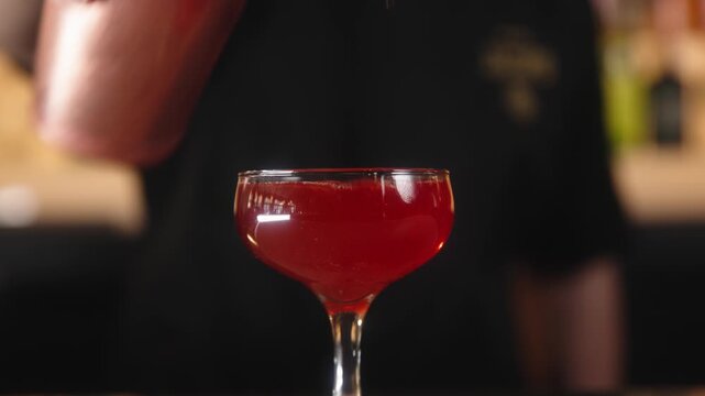 Barman pouring beverage in a glass.