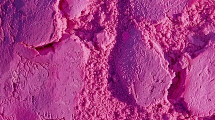 A close-up of a rough, pink surface with visible cracks. The rough texture of the ground. Powder or a dusty substance.