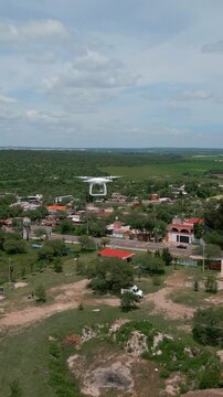 Dji drone used for topography flying in the air. In a countryside with a cloudy sky. Aerial drone view.