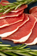 sliced ham with bacon on a board