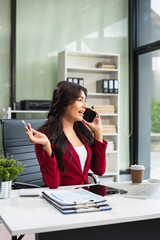 Obraz premium Asian businesswoman involved in cellphone call conversation giving professional consultation to client or negotiating project.