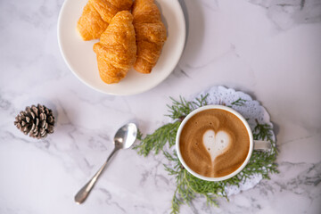 coffee cup with croissant with heart pattern