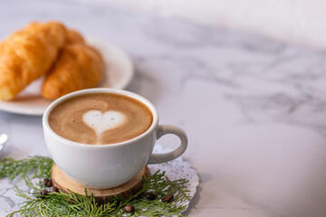 coffee cup with croissant with heart pattern