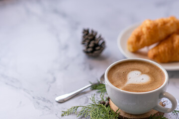 coffee cup with croissant with heart pattern
