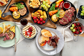 Table with grilled food. Pizza, corn, tomatoes, peppers, cooked meat. BBQ time