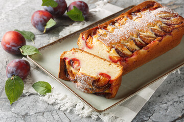 Fresh Plum Cake with yogurt and olive oil, the sponge is moist and flavourful closeup on the plate on the table. Horizontal