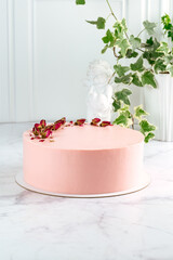 a whole cake decorated with dried roses on white marble