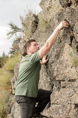 Man climbing on the side of a large rock