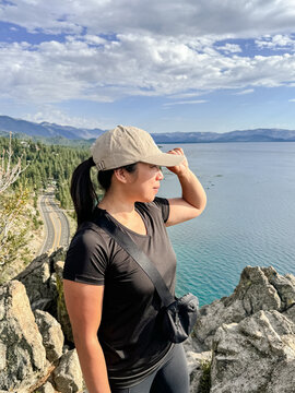Woman hiker holding her hat with Tahoe behind
