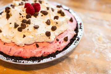 Close up of chocolate raspberry pie with fresh raspberries and c