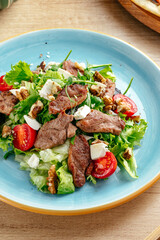 a warm salad with fried meat and sauce . restaurant menu