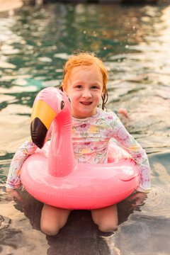 Little girl sitting in a flamingo pool float