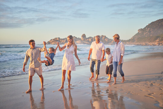 Holding hands, ocean and big family with vacation, happiness and travel for adventure, fun and play. Generations, beach and grandparents with mother, father and kids with childhood, smile and journey