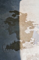 Water puddle on concrete stone cement flooring ground material with half ceiling shadows shade.