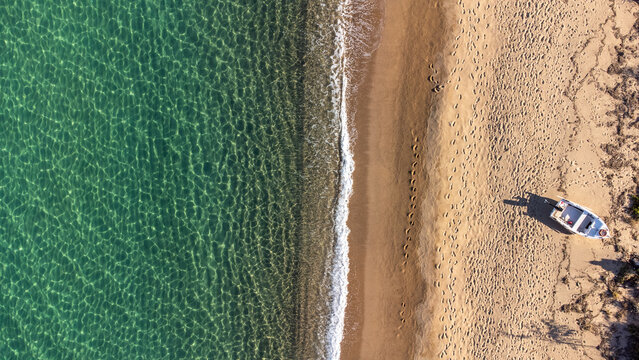 Top view of small fishing boat on sandy beach in Ierissos, Greece