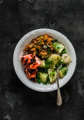Simple outdoor food - boiled potatoes with herbs, grilled salmon, caponata on a dark background, top view