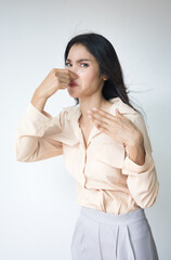 Young Adult Asian Woman covering her nose to prevent bad stinking smell, stinking odor and...