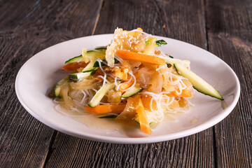 Asian Chopped Salad on wood table. Chinese food. wooden sticks, soy sauce.