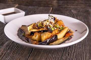 Chinese Eggplant with Garlic Sauce on wood table. Chinese food. wooden sticks, soy sauce.