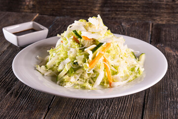 Asian Chopped Salad on wood table. Chinese food. wooden sticks, soy sauce.