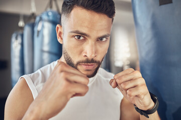 Man, portrait and fist for workout in gym for fighting tournament, match or training for competition. Male person, serious and ready for challenge or sport, self defense and mma performance or boxing