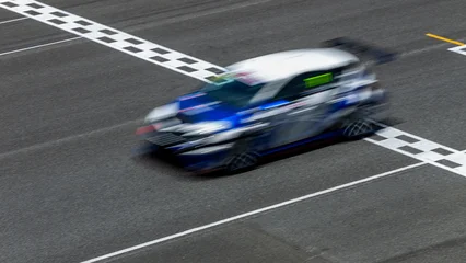 Fotobehang Formule 1 Motion blur race car racing on speed track, Car race on the international circuit race track crossing start and finish line, Race car crossing start and finish line, Target business achieve victory.  © Kalyakan