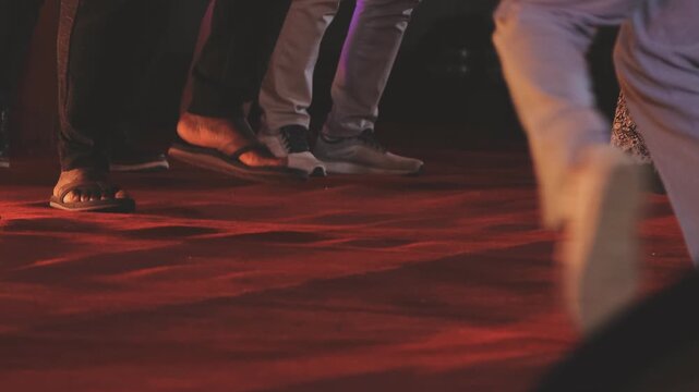 Dancing shoes of a couple, couples dancing traditional latin argentinian dance milonga in the ballroom, tango salsa bachata kizomba lesson, festival on wooden floor, purple, red and violet lights