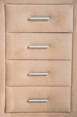 Beige cushioned dresser featuring drawers with sleek silver handles.