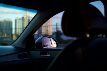 Side mirror of a car.
Headrest in a small car.
Reflection of evening street in rear view mirror