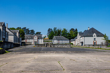 Empty indoor parking lot surrounded by buildings at central base of Charlemont fortress, green lush...