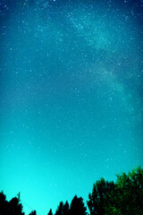 Captivating night sky image featuring a vast expanse of twinkling stars and the faint glow of the...