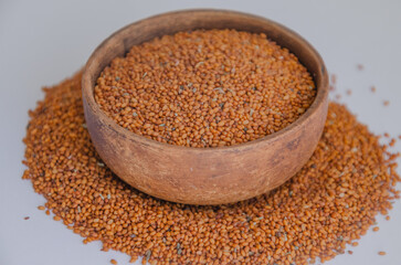 Camelina sativa seeds, camelina seeds in wooden bowl isolated on white background. Raw material for camelina oil.