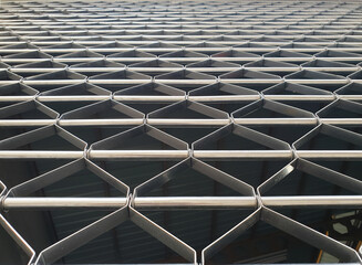 Close-up of a stainless steel rolling door with an unusual, beautiful linear and geometric pattern.