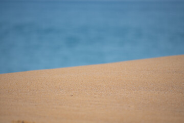 sand with blurred ocean water wave tropical beach bokeh background, summer vacation and travel concept with copy space.