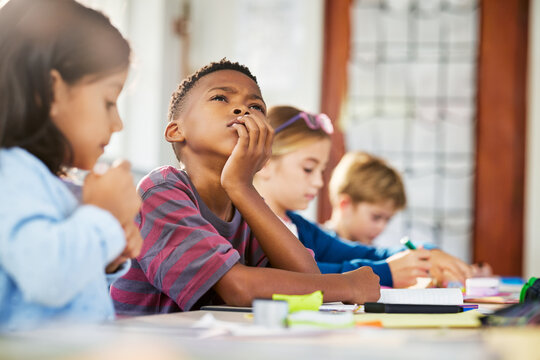 Pensive african school boy thinking during lesson