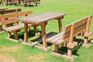 EMPTY WOODEN PICNIC TABLE WITH BENCHES on a green meadow in a pu