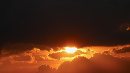 Panoramic aerial view of sunset under storm clouds with dramatic bright sunlight and silhouette clouds. Image use for meteorology forecast background.