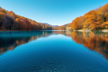 Obraz premium A large lake surrounded by autumn mountains with colorful foliage